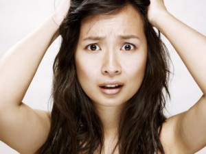 Young asian woman with hands on head --- Image by © 13/ballyscanlon/Ocean/Corbis